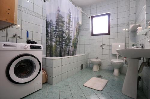 ein Badezimmer mit einer Waschmaschine und einem Waschbecken in der Unterkunft Romansa in Pale