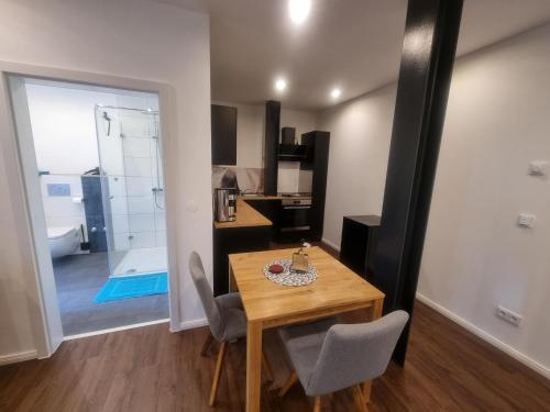 a dining room with a table and a bathroom at Ferienwohnungen An den SchwabachAuen - Keine Monteure in Eckental