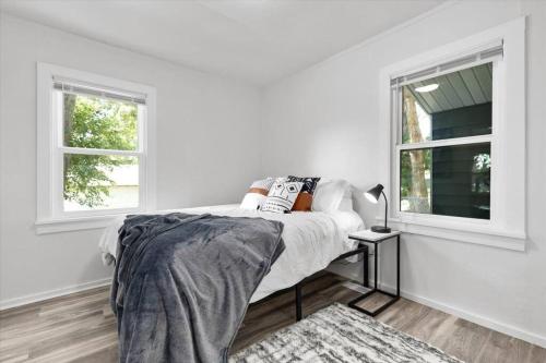 a white bedroom with a bed and two windows at 214: Lovely fully furnished 1 bedroom! in Billings