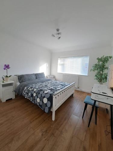a bedroom with a bed and a desk in it at GATWICK HOUSE in Crawley