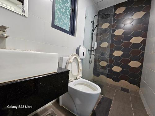 baño con aseo y pared de azulejos en Lovely Vivacity Jazz suite 2 Cozy Condo 2 Card LV7, en Kuching