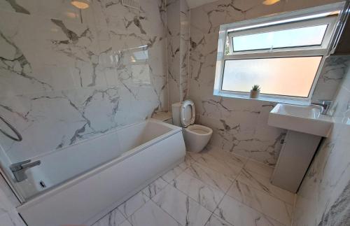 a bathroom with a tub and a toilet and a sink at GATWICK HOUSE in Crawley