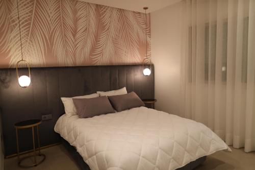 um quarto com uma grande cama branca e 2 almofadas em Cozy Apartment with Veranda Downtown em Casablanca