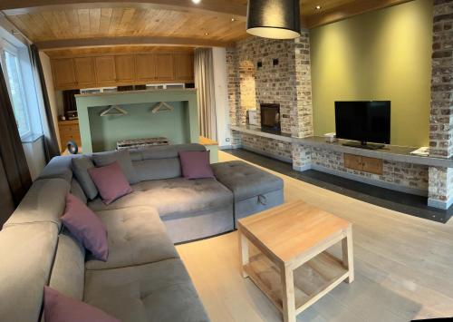 uma sala de estar com um sofá e uma televisão em B&B - Ter Douve em Dranouter
