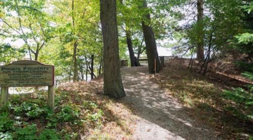 a sign in a park with trees and a trail at Indoor Pool near Grand Haven with Lake Michigan Beach! in Norton Shores