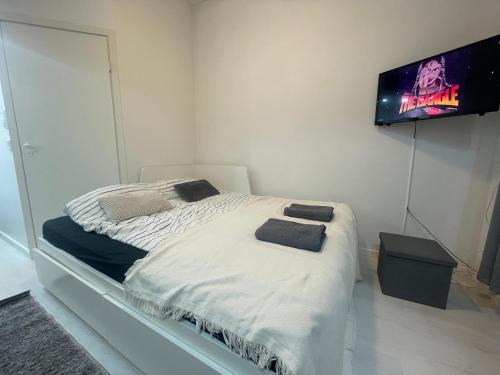 - une chambre avec un lit et une télévision murale dans l'établissement Cosy City Central Flat with self check-in, à Helsinki