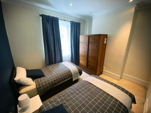 a bedroom with two beds and a window at 3-Bedroom Flat Central London, 6 Min Walk from King's Cross Station in London