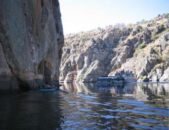 a body of water next to a rocky mountain at Posada Real La Mula de los Arribes in Villardiegua de la Ribera