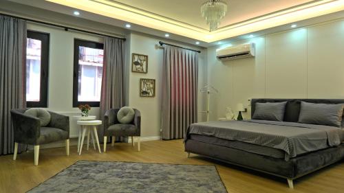 a bedroom with a bed and two chairs and a table at My Kent Hotel in Istanbul