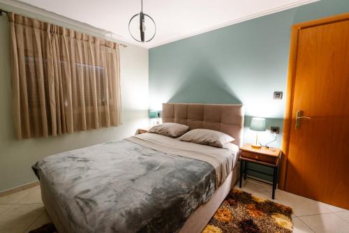 a bedroom with a large bed and a night stand at Alexandros Apartments in Paralía Proastíou