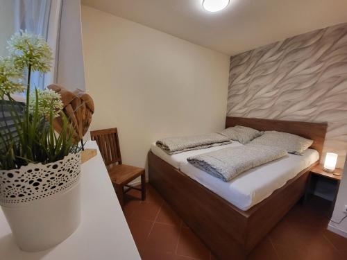 1 dormitorio con 1 cama y un jarrón con flores en Ferienwohnung Naturseelen mit Schwimmbad und Sauna, en Braunlage
