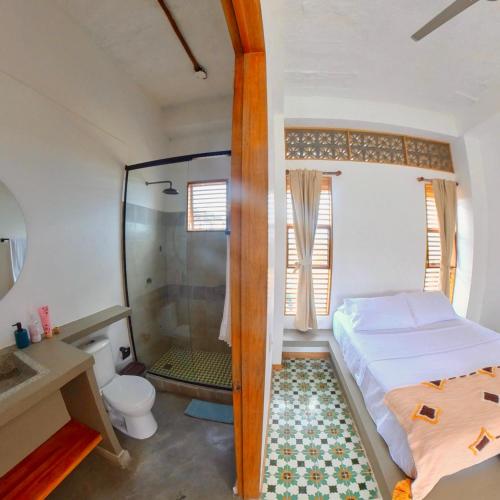 a bedroom with a shower and a bed and a toilet at Casa Mambo Salinas in Santa Veronica