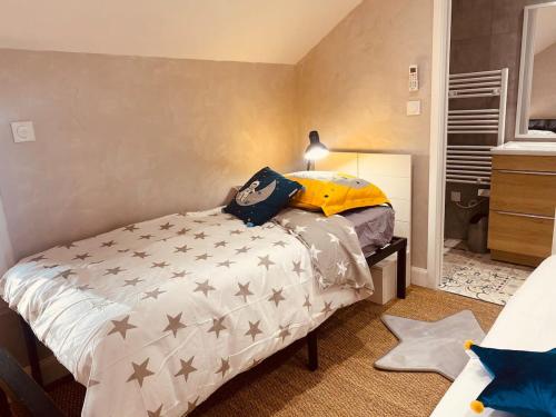 Un dormitorio con una cama con estrellas. en LA MARIEFACTURE - Comme dans les étoiles, en Boulay - Moselle