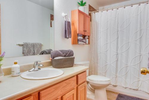 y baño con lavabo, aseo y cortina de ducha. en Central Soldotna Home Rental Near Kenai River!, en Soldotna