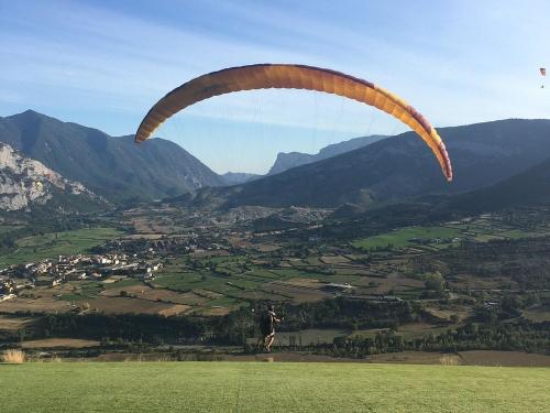 a person flying a parachute in a field at Càmping Organyà Park in Organyà