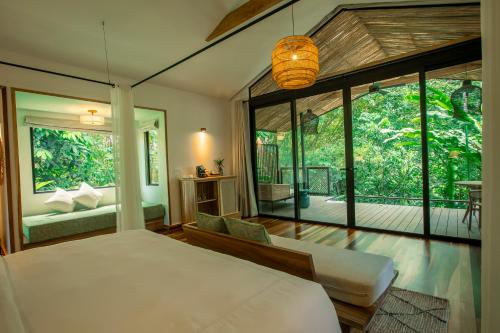 a bedroom with a bed and a large window at Nayara Gardens in Fortuna