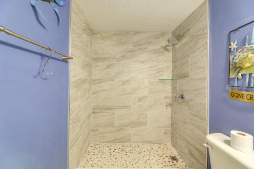 uma casa de banho com uma cabina de duche ao nível do chão com paredes azuis em North Carolina Escape with Balcony and Pool Access! em North Topsail Beach