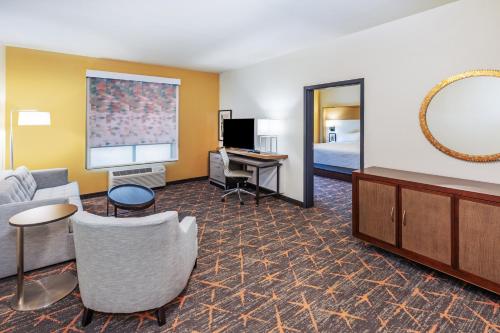a hotel room with a couch and a bed and a desk at Holiday Inn & Suites Stillwater-University West by IHG in Stillwater