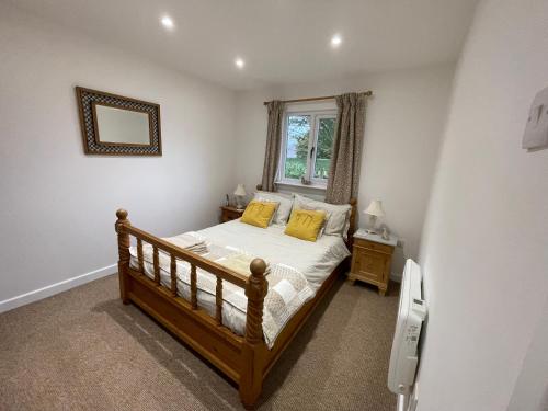 Un dormitorio con una cama con almohadas amarillas y una ventana en Little Owl Cottage, en Faversham
