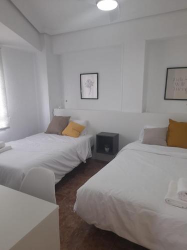two beds in a room with white walls at Mi casa de Molina in Molina de Segura