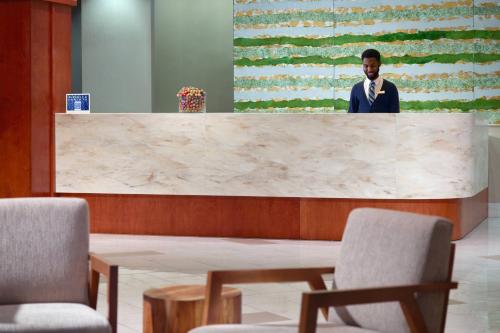 a man in a suit standing behind a marble counter at SpringHill Suites by Marriott Atlanta Buckhead in Atlanta