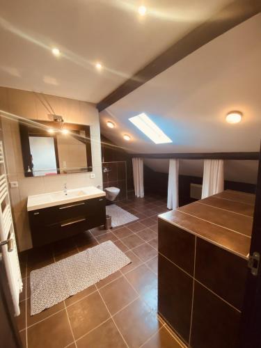 ein großes Bad mit einem Waschbecken und einem Spiegel in der Unterkunft LA MARIEFACTURE - Comme une Gourmandise ! 