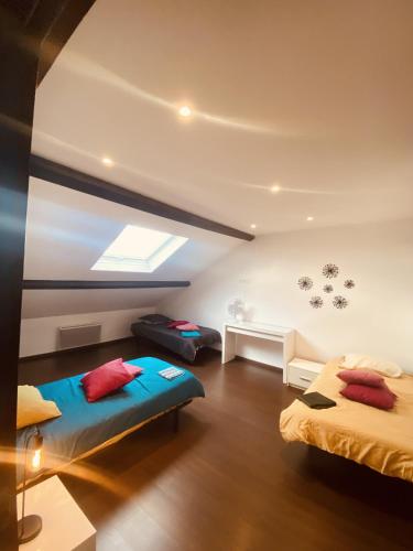 1 Schlafzimmer mit 2 Betten und einem Dachfenster in der Unterkunft LA MARIEFACTURE - Comme une Gourmandise ! 