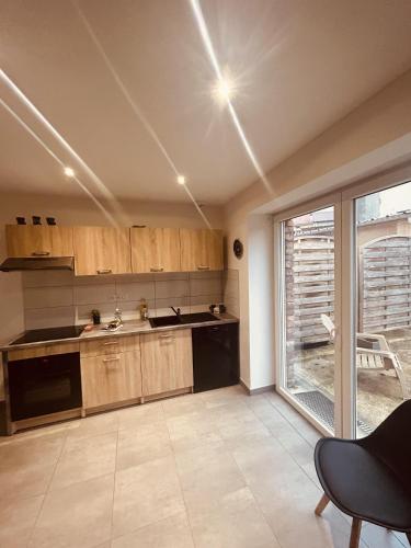 une cuisine avec des placards en bois et une grande fenêtre dans l'établissement LA MARIEFACTURE - Comme un Bretzel'Lover, à Longeville-lès-Saint-Avold