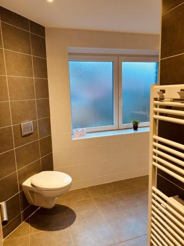 的住宿－LA MARIEFACTURE - Comme un Bretzel'Lover，一间带卫生间的浴室和两个窗户。