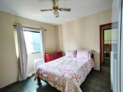 1 dormitorio con cama y ventana en Apartamento - Praia do Tombo, en Guarujá