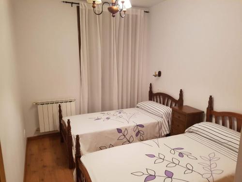卡連納德卡布拉雷斯的住宿－Apartamento en picos de europa，白色墙壁客房中的两张单人床