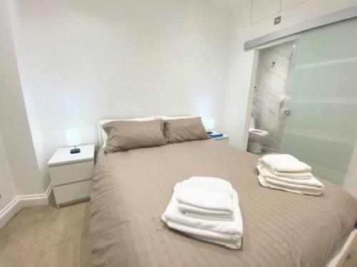 a bedroom with a bed with white towels on it at 2 Bedroom Flat in Whitechapel! in London