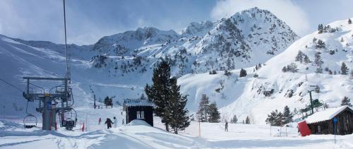 a snow covered mountain with people on a ski lift at Càmping Organyà Park in Organyà