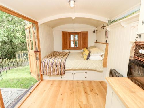 1 dormitorio en una casa pequeña con 1 cama en The Happy Hut en Christchurch