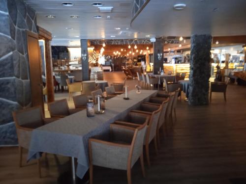 une salle à manger avec une grande table et des chaises dans l'établissement Ellivuori, Ellin Pooli2, à Sastamala