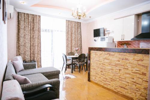 ein Wohnzimmer mit einem Sofa und einem Tisch mit Stühlen in der Unterkunft Ekaterine's Apartments in Batumi