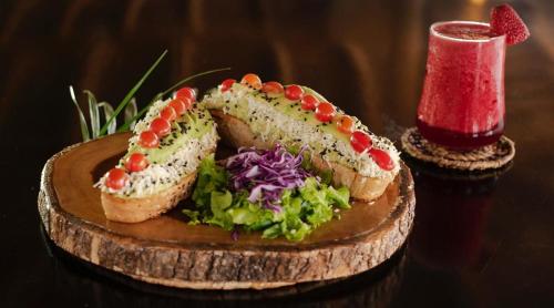 a wooden plate with two sandwiches and a salad at Dharma Beach in Montañita