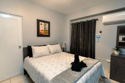 una camera da letto con un gatto nero seduto su un letto di Green Mountain Studio 2, pool table-7 min to beach a Rincon
