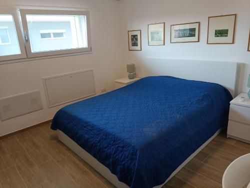 a bedroom with a blue bed and two windows at Bilocale a Rho in classe A con Garage in Rho