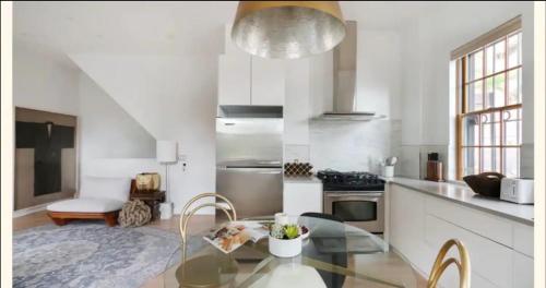 a large white kitchen with a glass table in it at 334-1 2BR - 1Bath prime Dumbo in Brooklyn