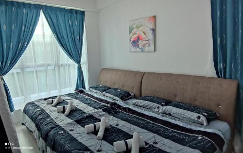 a large bed in a bedroom with blue curtains at Leisure homestay@Sutera Avenue 2-0519 in Kota Kinabalu