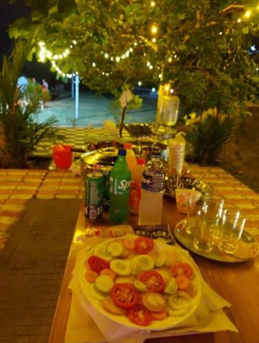 a wooden table with a plate of food on it at Serene Blossom Valley in Tenkāsi
