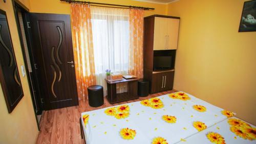 Un dormitorio con una cama con flores. en Pensiunea mălin și răzvan (chillbrothers) en Baile Felix