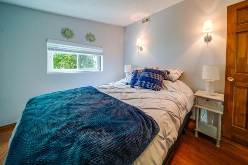 um quarto com uma cama com paredes azuis e uma janela em Cozy Erie Vacation Rental with Patio and Seasonal Pool em Erie
