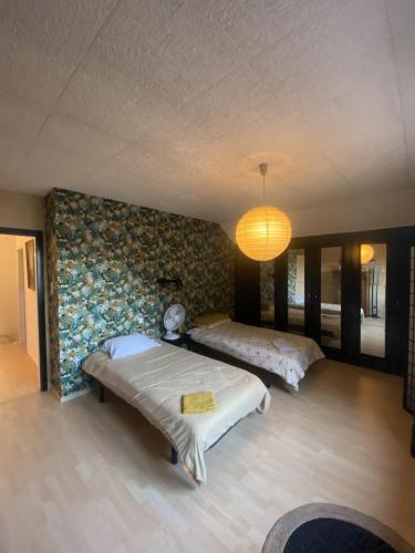 une chambre avec deux lits et un mur dans l'établissement LA MARIEFACTURE - Comme à la Guinguette !, à Hombourg-Haut