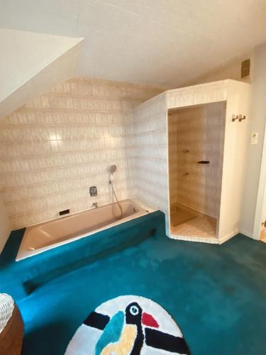 Cette chambre comprend une baignoire et un oiseau peint au sol. dans l'établissement LA MARIEFACTURE - Comme à la Guinguette !, à Hombourg-Haut