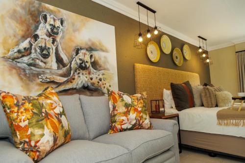 a living room with a couch and a painting of dogs at Pumbaa Wildlife Park & Accommodation in Nelspruit