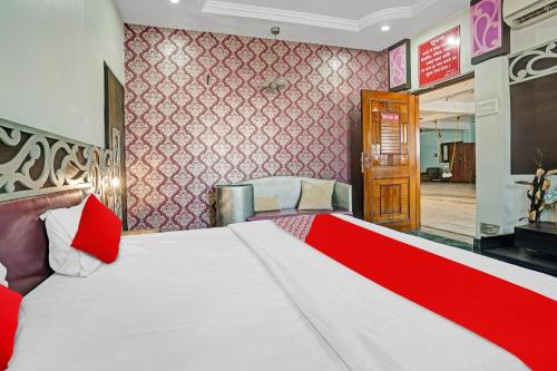 a bedroom with a large white bed with red pillows at Flagship Hotel Pragya 4 in Raipur