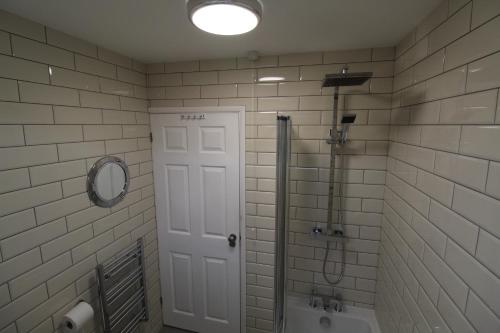 a bathroom with a shower and a toilet and a door at Driftwood Heart in Freshwater