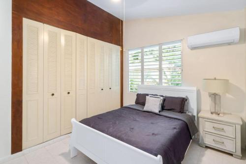 ein weißes Schlafzimmer mit einem Bett und einem Fenster in der Unterkunft Villa Ensueno a 3 bdr house in the mountain in Rincon
